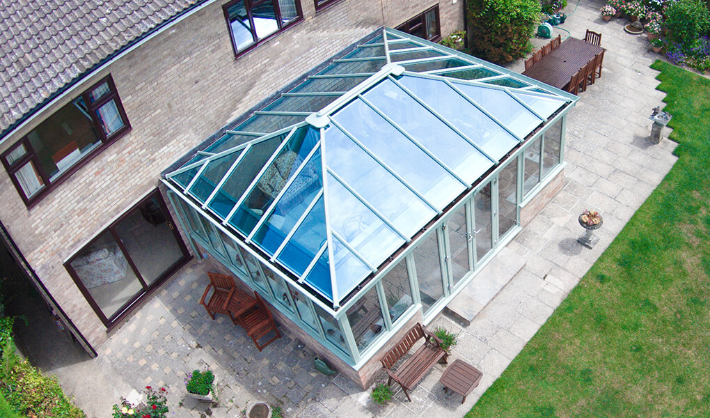 Sage green uPVC Edwardian conservatory with a glass roof