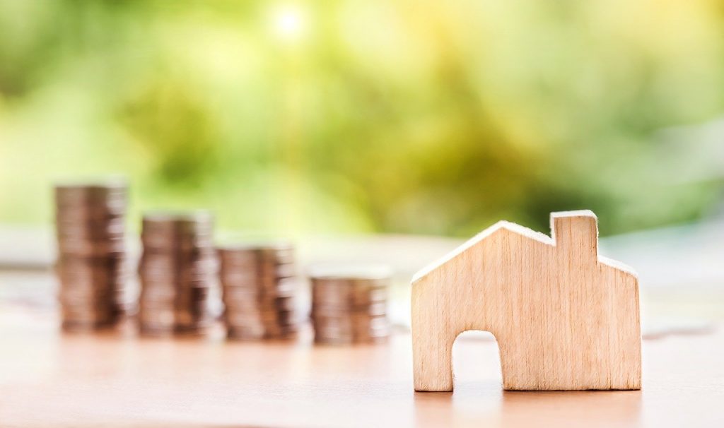 Picture of a wooden house with money in the background