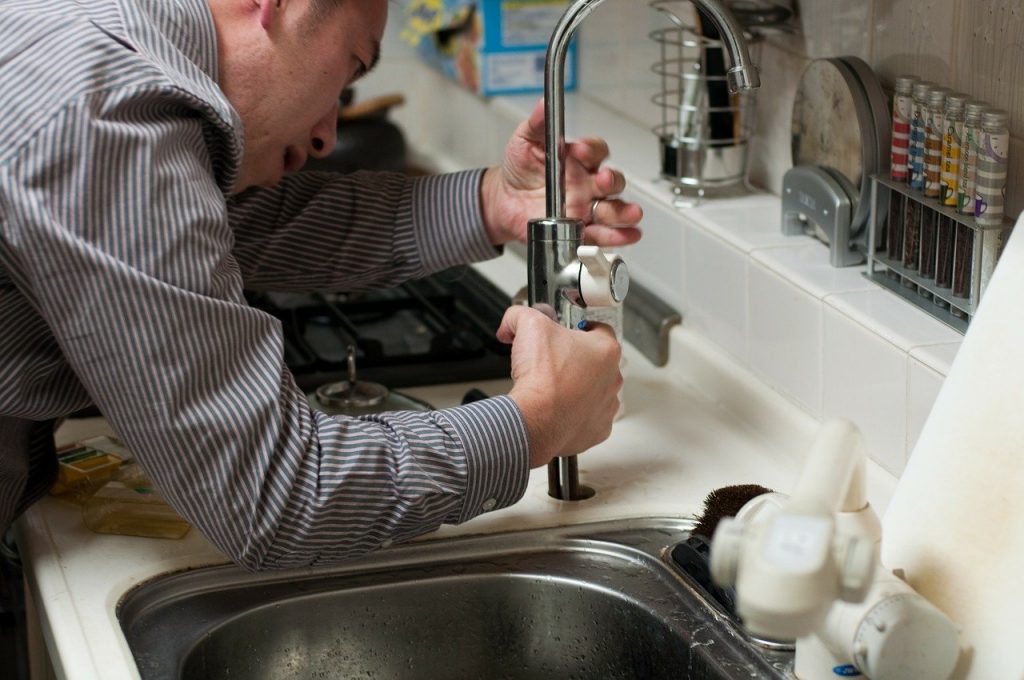 Man trying to fix a tap